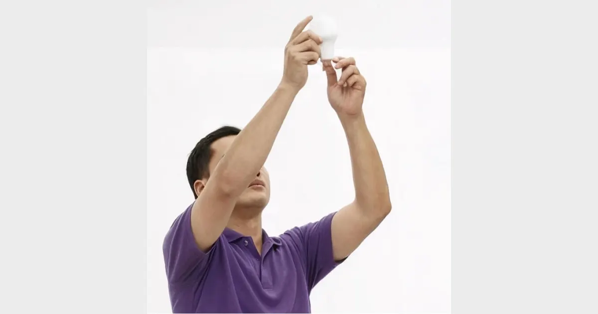 Urban Company electrician changing a ceiling light bulb