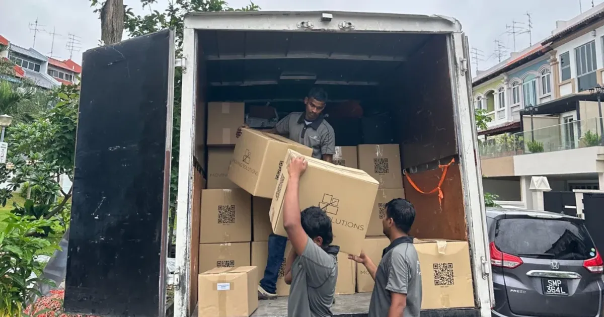 Movings.sg team moving boxes from a lorry outside a house