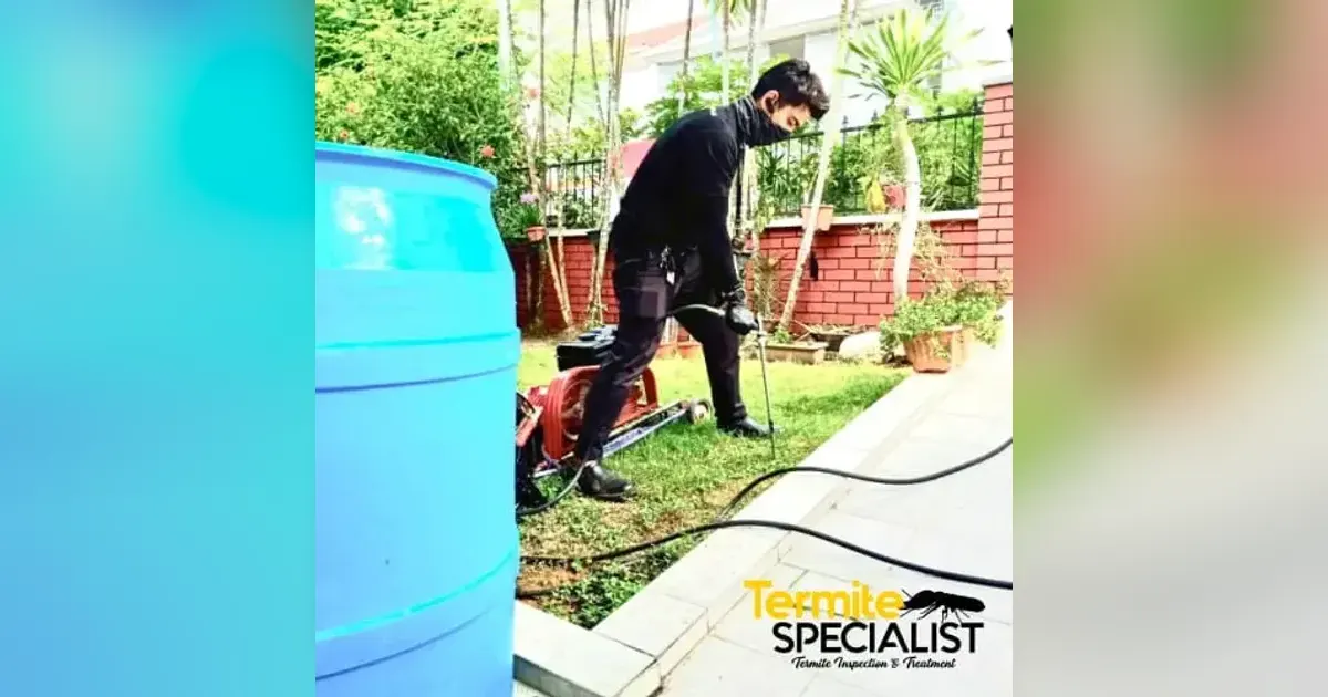 Termite Specialist technician treating soil in a garden